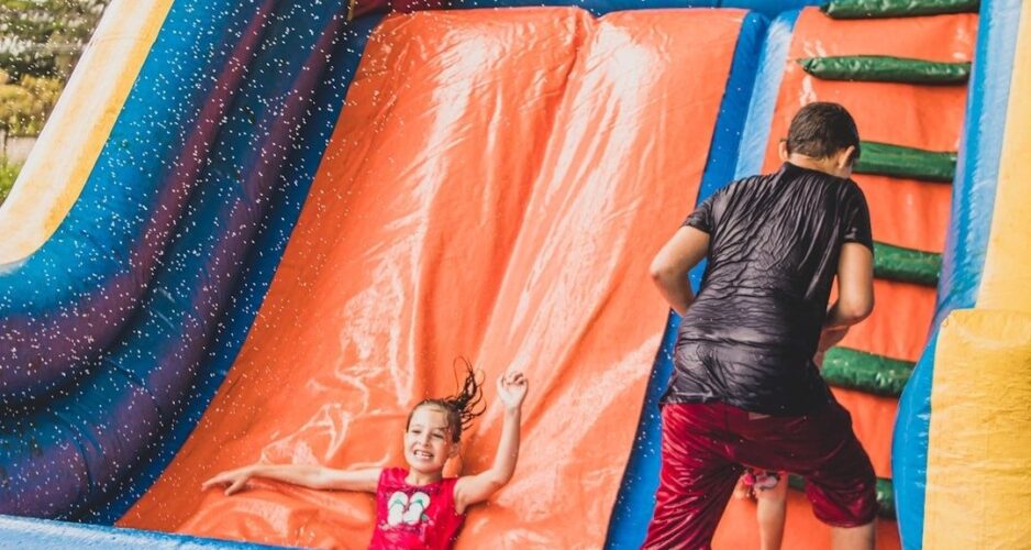 Kinderen spelen op een nat springkussen tijdens een buitenspeelactiviteit